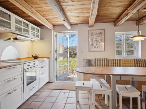 a kitchen with white cabinets and a wooden ceiling at Holiday Home Elisabetha - 16km from the sea by Interhome in Randbøl