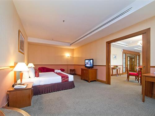 a hotel room with a bed and a television at Seeds Hotel Premier Sri Petaling in Kuala Lumpur