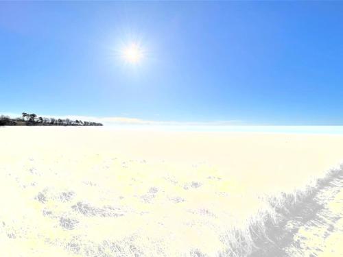 a sandy beach with the sun in the sky at Holiday Home Vemund - 100m to the inlet by Interhome in Vig