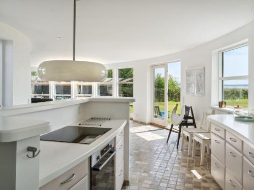 a kitchen with white counters and a large window at Holiday Home Vemund - 100m to the inlet by Interhome in Vig