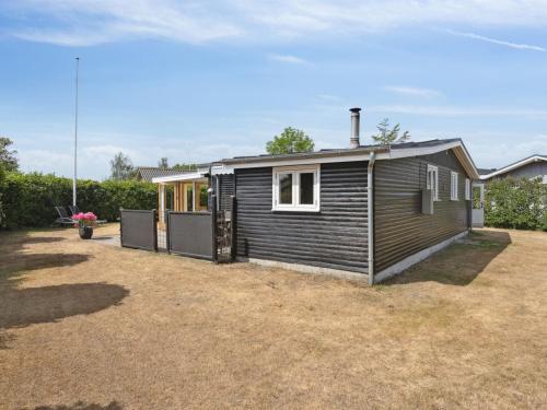 a small house in a field with a yard at Holiday Home Sari - 250m from the sea by Interhome in Sønderby