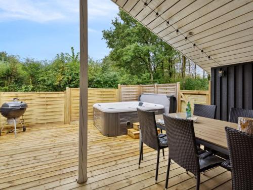 a patio with a hot tub on a wooden deck at Holiday Home Brynhild - 30km from the sea by Interhome in Toftlund