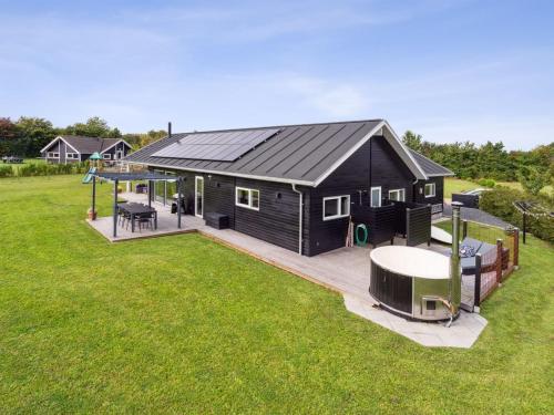 a black house with a gazebo in a yard at Holiday Home Amdi - 700m from the sea by Interhome in Neder Lysabild
