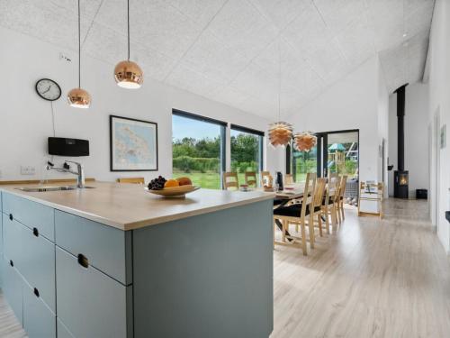 a kitchen and dining room with white cabinets and a table at Holiday Home Amdi - 700m from the sea by Interhome in Neder Lysabild