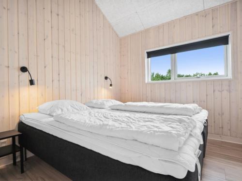 a bedroom with a large bed with a window at Holiday Home Amdi - 700m from the sea by Interhome in Neder Lysabild