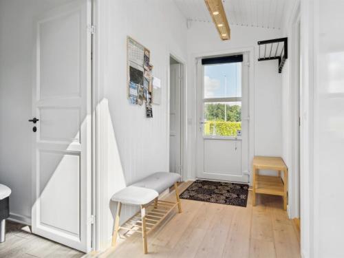 a room with a door and a chair and a table at Holiday Home Fiete - 200m from the sea by Interhome in Binderup Strand