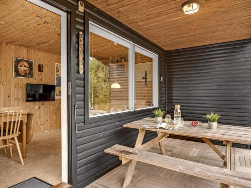 a patio with a wooden table and a window at Holiday Home Fifi - 200m to the fjord by Interhome in Skjern