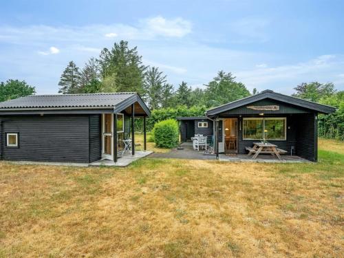 a black shed with a patio and a picnic table at Holiday Home Fifi - 200m to the fjord by Interhome in Skjern