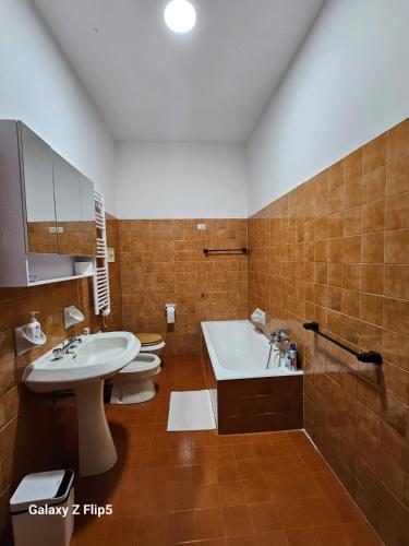 a bathroom with two toilets and a sink and a tub at CASA MIA GUESTHOUSE AFFITTA CAMERE Foresteria 