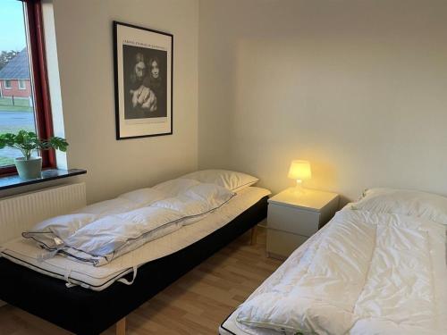 two twin beds in a room with a window at Holiday Home Ingward - 750m from the sea by Interhome in Vestervig