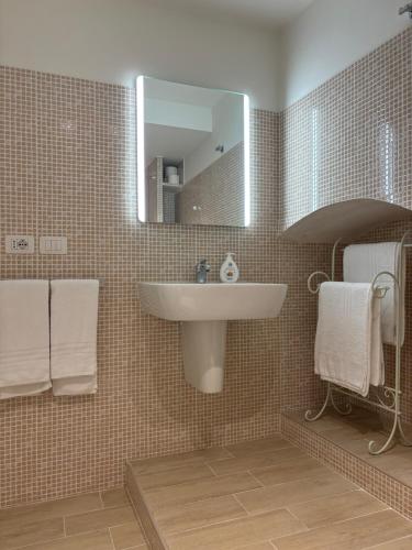 a bathroom with a sink and a mirror and towels at Torretta dependance in Assisi