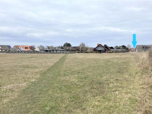 a field of grass with houses in the background at Holiday Home Ottmar - 150m from the sea by Interhome in Bagenkop