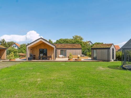 a house with a green lawn in front of it at Holiday Home Ottmar - 150m from the sea by Interhome in Bagenkop