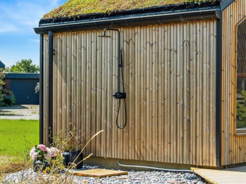 a wooden shed with a shower in it at Holiday Home Ottmar - 150m from the sea by Interhome in Bagenkop