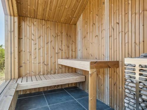 a wooden sauna with a bench in it at Holiday Home Ottmar - 150m from the sea by Interhome in Bagenkop