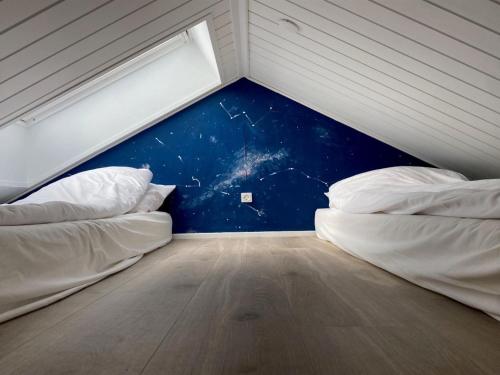two beds in a room with a blue wall at Holiday Home Ottmar - 150m from the sea by Interhome in Bagenkop