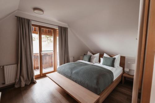 a bedroom with a bed and a large window at Ferienhaus Am Grassnitzberg 18 in Straß in Steiermark