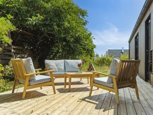 two chairs and a table on a wooden deck at Holiday Home Ottmar - 150m from the sea by Interhome in Bagenkop