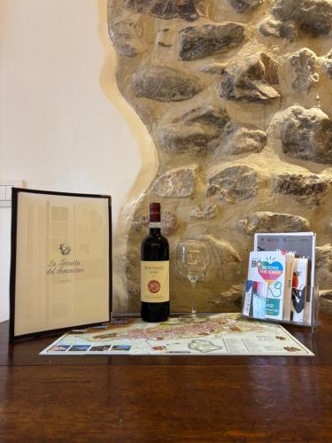 a bottle of wine and a glass on a table at Torretta dependance in Assisi