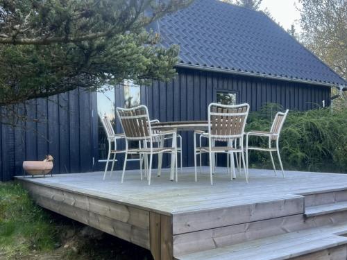 a deck with chairs and a table on it at Holiday Home Ewy - 150m to the fjord by Interhome in Fur