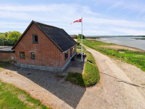 a red brick building with a flag next to a road at Holiday Home Swaantje - 150m to the fjord by Interhome in Fur