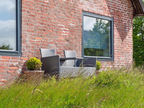 a brick building with a table and chairs in the grass at Holiday Home Swaantje - 150m to the fjord by Interhome in Fur