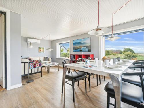 a dining room with a white table and chairs at Holiday Home Swaantje - 150m to the fjord by Interhome in Fur