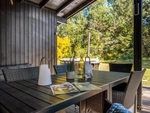 a table on a porch with chairs and a window at Holiday Home Eli - 1-5km to the fjord by Interhome in Blåvand