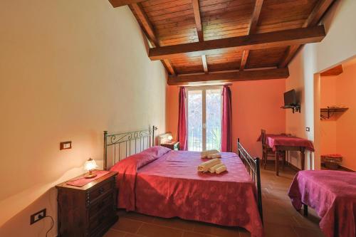 a bedroom with a bed with red sheets and a wooden ceiling at Bed And Breakfast Sciarammola in Patti