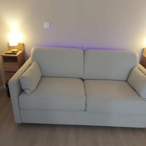 a white couch in a living room with a lamp at Le Chti Paradis in Méricourt