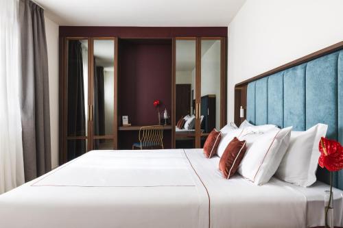 a bedroom with a large white bed with pillows at Casa D'Este - Hotel Ferrara in Ferrara