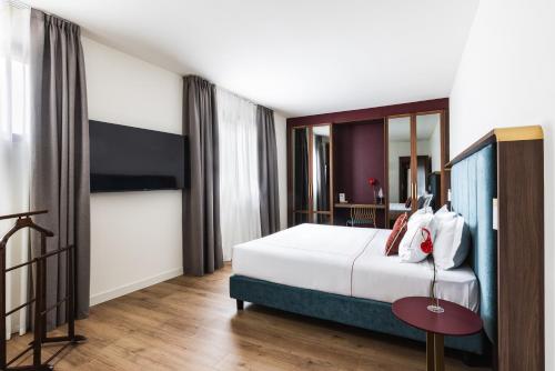 a bedroom with a large white bed and a table at Casa D'Este - Hotel Ferrara in Ferrara