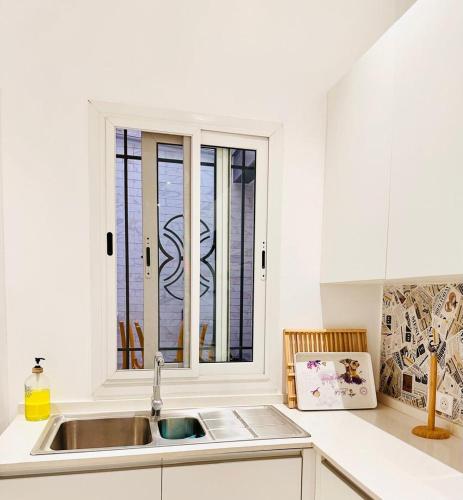 a white kitchen with a sink and a window at Cozy, fully equipped apartment in Mermoz, Dakar in Dakar