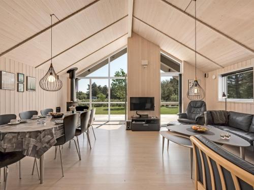 une salle à manger et un salon avec une table et des chaises dans l'établissement Holiday Home Elina - 600m from the sea by Interhome, à Blåvand
