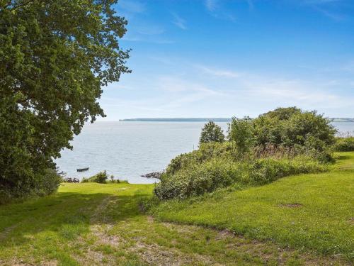 un campo de césped con vistas al agua en Holiday Home Arnetta - 150m from the sea by Interhome, en Sønderby