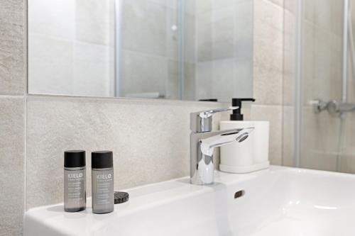 a bathroom sink with two products sitting on it at Mykeypers- Design & Cosy Apartment 2P - Malakoff 25 in Malakoff