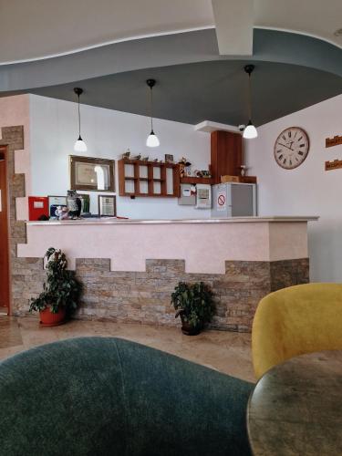 a living room with a counter and a clock on the wall at Motel Citadela 023 in Zrenjanin