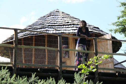 a woman standing on a fence in a house at Terragora Lodges - Hébergement atypique in Les Épesses