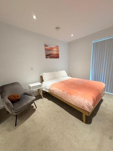 a bedroom with a bed and a chair at Cosy Two bedroom Apartment in Manchester in Manchester