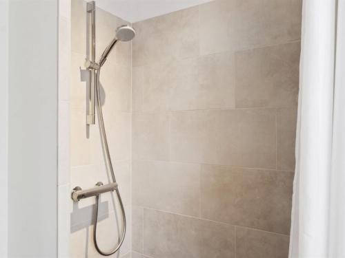 a shower with a shower head in a bathroom at Holiday Home Esme - 30m from the sea by Interhome in Dannemare