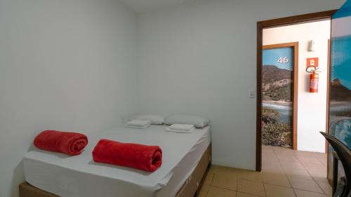 a white bed with two red towels on it at Smart Hostel - Floripa in Florianópolis