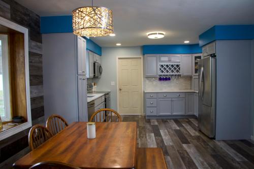 a kitchen with a wooden table and a refrigerator at Cozy Meets Luxury in Tylersville