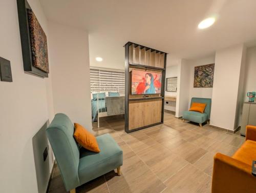 a living room with a couch a chair and a television at Lienzo Suite in Popayan