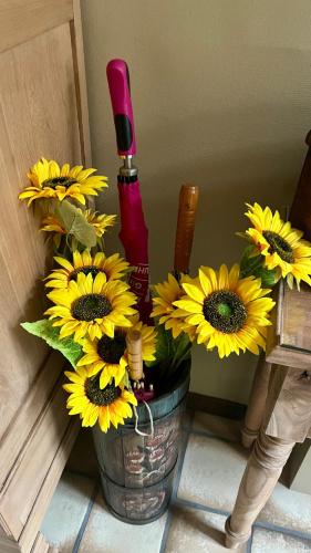 a vase with sunflowers and a bottle of lipstick at In De Wulf in Ypres