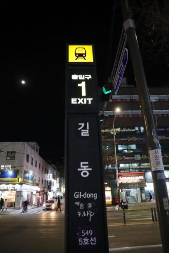 a sign on the side of a street at night at 넘버25호텔 길동점 in Seoul