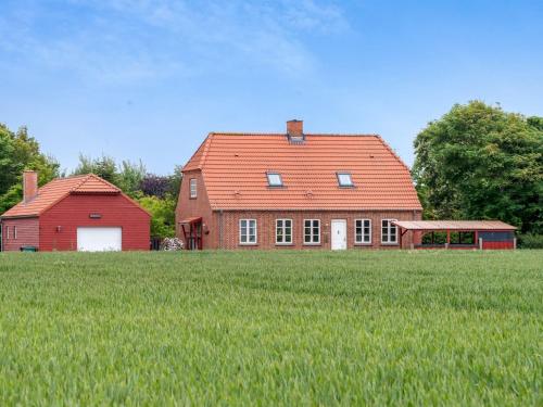 a large red house in a field of green grass at Holiday Home Soria - 600m to the fjord by Interhome in Vemb