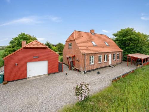 a red house and a red barn with a garage at Holiday Home Soria - 600m to the fjord by Interhome in Vemb