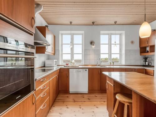 a kitchen with wooden cabinets and a wooden floor at Holiday Home Soria - 600m to the fjord by Interhome in Vemb