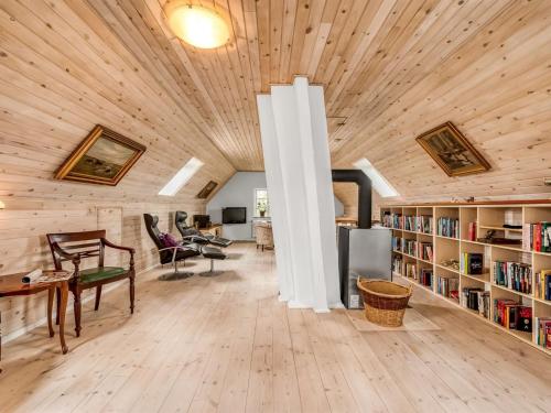 a living room with a wooden ceiling and bookshelves at Holiday Home Soria - 600m to the fjord by Interhome in Vemb