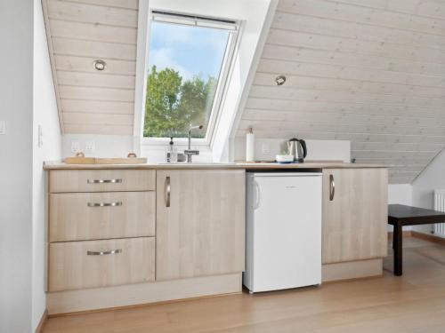 a kitchen with wooden cabinets and a window at Apartment Dietlinde - 1-3km to the inlet by Interhome in Thyholm